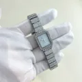 Detailed close-up of sparkling rhinestone square quartz watch with dazzling crystal pave band. - Silver