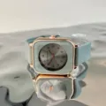 Close-up detail of the minimalist square quartz watch featuring mint green silicone strap. - Grey Green