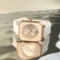 Close-up details of square quartz watch featuring rose gold case and white silicone strap. - White