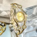 Modische goldene Quarz Damenuhr mit auffälligem Kettenarmband und glänzender Strass-Lünette. - Gold
