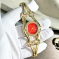 Luxus Damen Quarzuhr mit rotem Zifferblatt, Strasslünette und goldenem Kettenarmband. - Rot