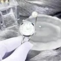 Elegante Perlen-Manschetten-Quarzuhr mit glitzernden Strasssteinen und schickem Silber-Armreif. - Rundes Zifferblatt / Silber