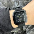 Nahaufnahme der schwarzen quadratischen Quarzuhr am Handgelenk mit Silikonarmband. - Schwarz
