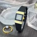 Nahaufnahme der quadratischen Quarzuhr mit schwarzem Silikonarmband und goldenem Metalldekor. - Schwarz