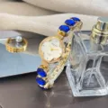 Damen Quarzuhr mit blauen Kleeblatt Gliedern, goldenem Metallarmband und stilvollem Gehäuse. - Blau