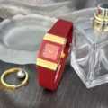 Nahaufnahme der luxuriösen roten quadratischen Quarzuhr mit goldenen Akzenten und Armband. - Rot