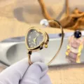 Elegante herzförmige Quarzuhr als Armreif mit Perlenakzent, französischer romantischer Schmuck. - Herz Schwarzes Zifferblatt / Gold