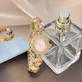 Detailansicht der luxuriösen goldenen Quarzdamenuhr mit rosa Zifferblatt und Strass. - Rosa
