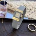 Elegante quadratische Quarzuhr mit grauem Silikonarmband und edlem goldfarbenen Zifferblatt. - Grau