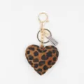 Close-up detail of a chic leopard print heart keychain with gold metal clasp and tassel charm. - Coffee Tassel Keychain