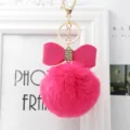 Detailed view of pink faux fur pom pom keychain, cute bow bag charm and shining metal hardware. - 8cm Pompom / Rose Red