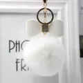 White faux fur pom pom keychain with elegant leather bow and gold hardware charm. - 8cm Pompom / White