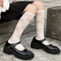 Detailed view of white lace ruffle JK lolita socks paired with black Mary Jane shoes. - One Size / White Calf Length