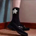 Close-up detail of black calf socks featuring elegant white pearl flower decoration. - One Size / Sunflower Double Needle Striped Pearl Mid Tube Socks / Black