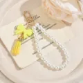 Primo piano dettagliato del portachiavi di perle con un fiocco giallo e una nappa. - giallo limone