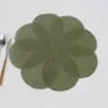 Close up view of green woven petal table mat detail, heat insulation placemat for dining table. - Green