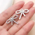 Silver tone alloy bow charm with pearl inlay and hollow design for DIY jewelry making accessories. - Pearl Rhinestone Bowknot (27028) / 1 Piece (19x23mm) / Silver