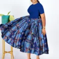 Detail view of a blue short-sleeve top and printed flared skirt outfit on a model. - 1XL / Dresses / Blue
