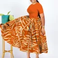 Detail view of a stunning plus size African style orange pleated maxi dress with elegant leaf print. - 1XL / Dresses / Orange