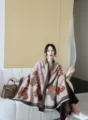 Close-up view of the elegant floral jacquard winter shawl worn by the model indoors. - Grey Deer & Flowers Pattern