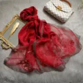Detailansicht des roten Begonien bestickten Seide-Wolle-Schals mit glitzerndem Silberrand. - Rot