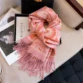 Detailed shot of pink paisley jacquard scarf with cozy fringe, elegant winter shawl prop. - Pink