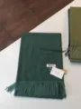 Dunkelgrüner einfarbiger Kaschmirimitat-Schal mit Fransen, Detailansicht von Textur und Etikett. - Meliertes Grasgrün