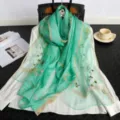 Green embroidered silk scarf with elegant gold border and delicate floral patterns. - Light Green