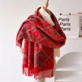Detailed shot of thick red patterned winter scarf with retro geometric print and tassel hem. - Red