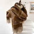 Detailaufnahme des braunen karierten Winterschals mit Fransen und weicher Stofftextur. - Dunkelbraun Kariert