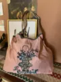 Detailansicht der großen Schultertasche mit gesticktem Blumenmuster und gewebten Trägern. - Rosa Blumenkorb