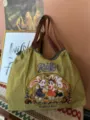 Vista dettagliata della borsa a tracolla verde oliva con ricamo di coniglio e ampia tracolla tessuta. - Coniglio verde