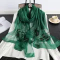 Vista detallada del pañuelo de seda verde oscuro con delicados motivos florales y cuentas. - Verde