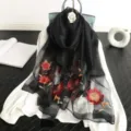 Detailaufnahme des schwarzen, transparenten Schals mit edler Blumenstickerei und Pailletten. - Schwarz / 190cm