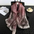 Detailed view of the elegant pink silk embroidered scarf with floral pattern and fine border. - Purple