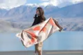 Outdoor detail view of a thick winter jacquard fringe shawl and warm cashmere scarf accessory. - Orange Moon Shadow Autumn Osmanthus