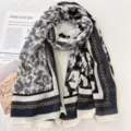 Detaillierte Detailansicht eines schicken Schals mit elegantem Kettenmuster und Print. - Grau