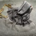 Detailsicht des eleganten Seide-Wolle-Verlaufsschals mit schimmerndem Metallic-Saum und Textur. - Grau