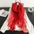 Detailansicht eines luxuriösen roten Seide-Wolle-Mischschals mit elegantem Goldstreifenmuster. - Rot
