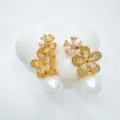 Detailed close-up of sparkling gold-plated flower cubic zirconia earrings with elegant pearl drops. - Stud Earrings / Gold (Acrylic Pearl)