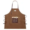 Grembiule da lavoro marrone in tela con bretelle in pelle e tasche per attrezzi da giardino. - Caffè