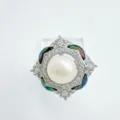 Close-up detail of a delicate DIY pearl ring with a central pearl and shiny crystals. - Abalone Shell Ring With Artificial Pearl / Silver