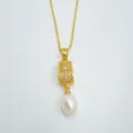 Close up detail of elegant gold plated pendant necklace featuring sparkling paved stones and natural pearl. - Pendant / Artificial Pearl (Without Chain) / Gold