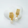 Gold-plated cubic zirconia pearl drop earrings, elegant jewelry detail shot showing fine craftsmanship. - Stud Earrings / Natural Pearl / Gold