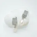 Close-up detail shot of exquisite pave stone rectangular earrings featuring elegant dangling pearls. - Stud Earrings / Natural Pearl / Silver