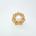 Nahaufnahme Detail des Luxus Blumen Perlen Rings mit Zirkonia und Goldbeschichtung. - Ring mit Acrylperle / Gold