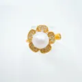 Nahaufnahme des eleganten Perlenrings mit vergoldeten Blütenblättern und funkelndem Zirkonia. - Ring (Goldfarben Acrylperle)