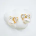 Close-up of pearl zirconia earrings, golden metal setting, elegant jewelry detail. - Heart Style - Gold - Acrylic Bead