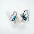Elegant butterfly pearl earrings detail closeup, featuring sparkling cubic zirconia and blue oil drip. - Stud Earrings - Silver (Artificial Pearl)