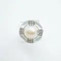 Close-up of the geometric pearl ring featuring mother-of-pearl and dazzling cubic zirconia. - White Shell Ring - Silver / Faux Pearl